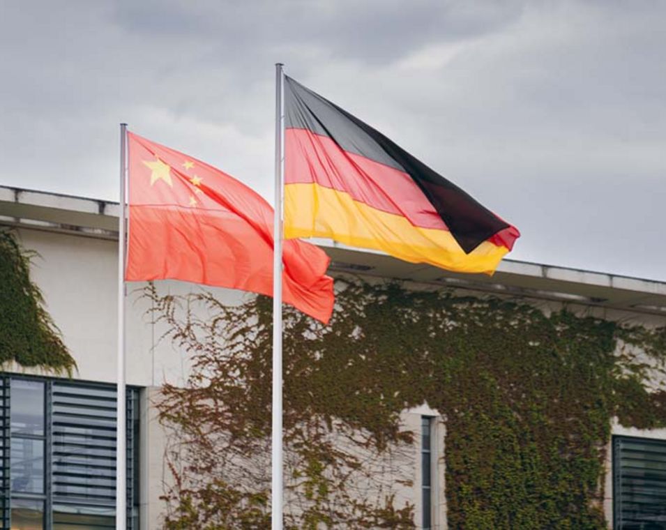 Eine deutsche und eine chinesische Flagge wehen im Wind.