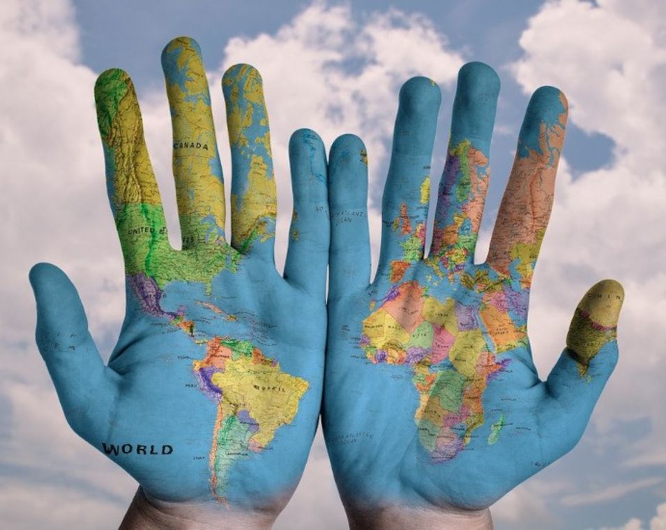 Das Bild zeigt zwei Hände mit Weltkarte.