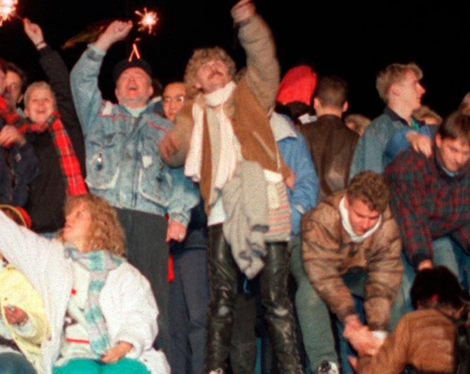 Menschen feiern auf der Berliner Mauer