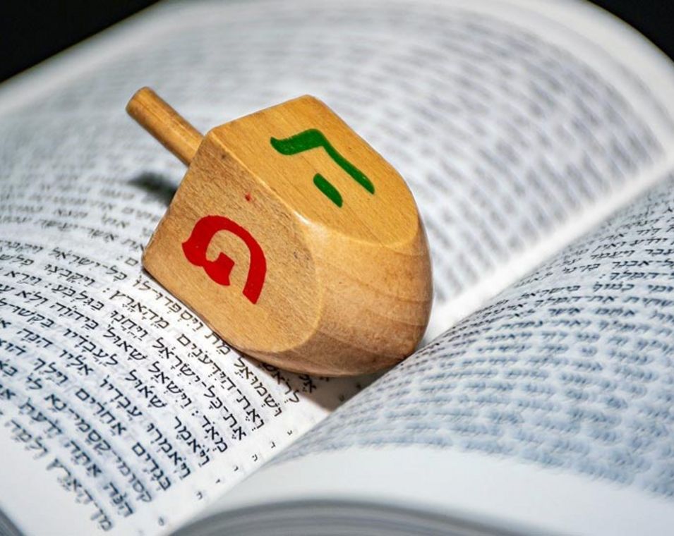 Auf der hebräischen Bibel "Tora" liegt ein Dreidel, ein Gebetskreisel mit vier Seiten. 