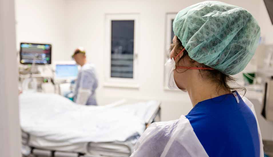 Pfleger und Ärztin schauen nach einer Patienten auf einer Intensivstation