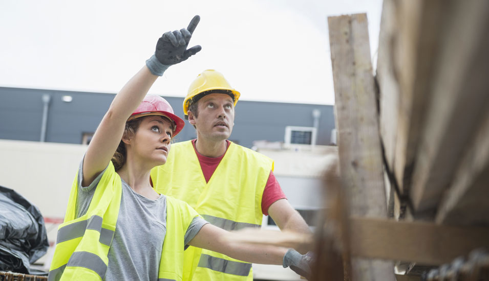 Das Foto zeigt eine Frau und einen Mann auf einer Baustelle, Ingenieure.
