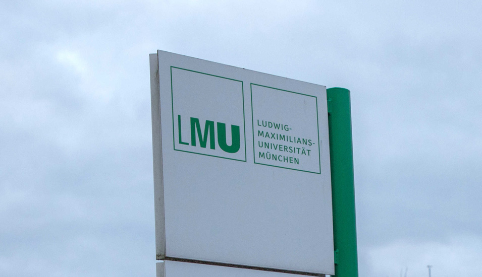 Schild mit Logo der LMU München vor grauem Himmel.
