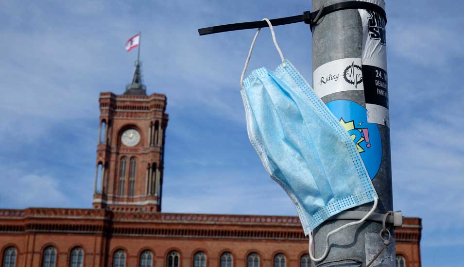 Eine Atemschutzmaske hängt an einer Laterne in Berlin
