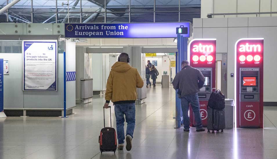 Einreise für EU-Bürger am Londoner Flughafen Stansted, man sieht einen Mann mit Rollkoffer von hinten.