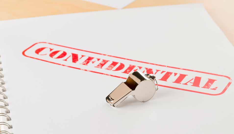 Eine Trillerpfeife liegt auf einem Dokument mit dem Stempelaufdruck Confidential