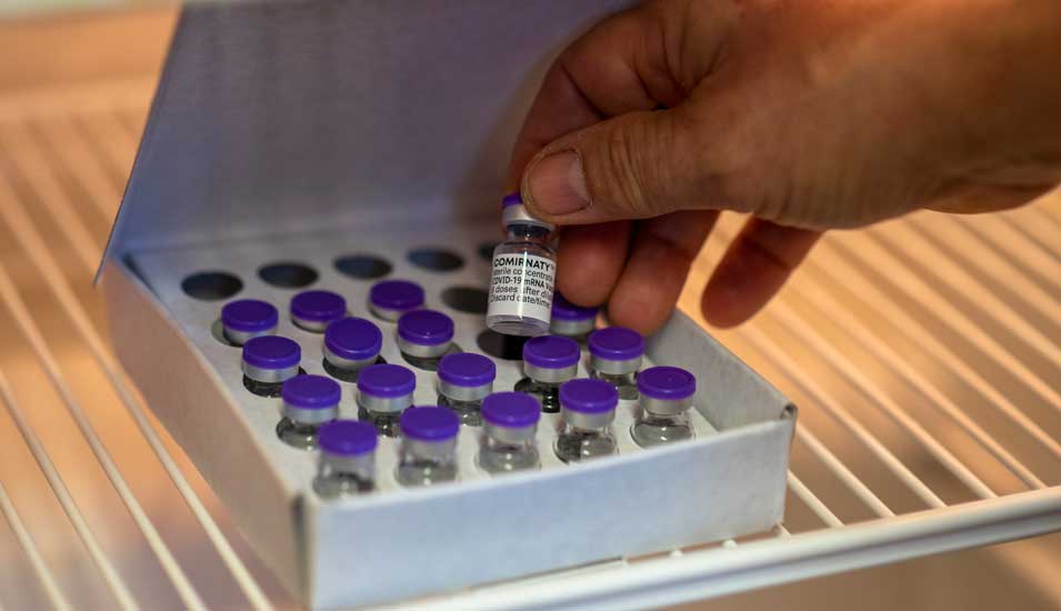 Eine Box mit Glasfläschchen des Covid-19-Impfstoffs von Biontech/Pfizer in einem Kühlschrank