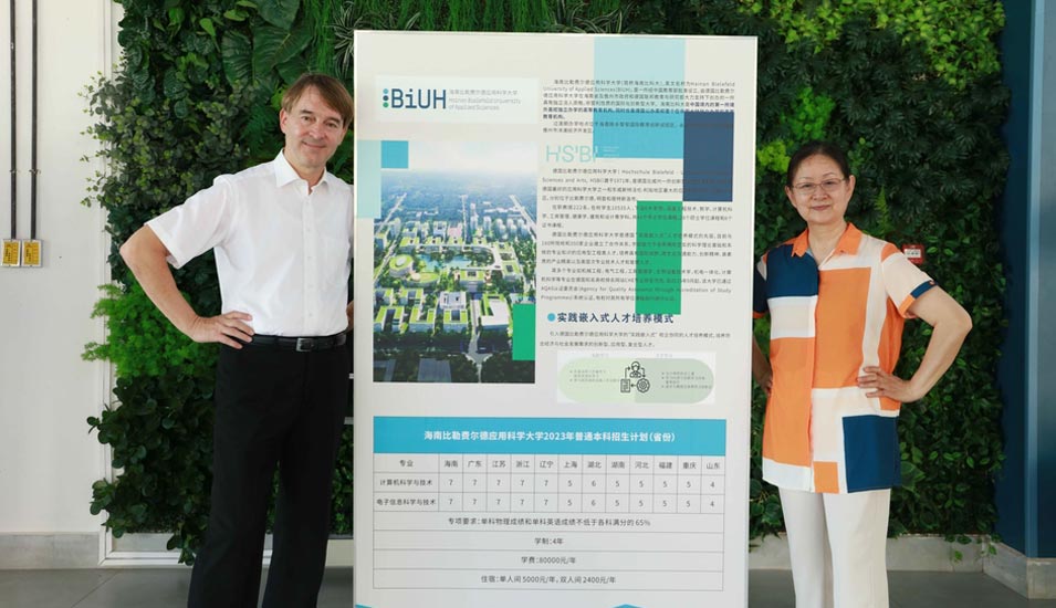 BiUH-Präsident Professor Jürgen Kretschmann und Kanzlerin Professorin Guan Naijia vor einem Plakat mit dem Bauvorhaben für den Campus der neuen Hochschule in Hainan. 