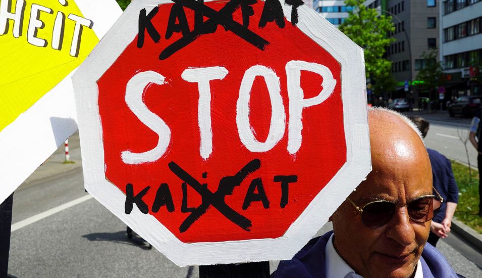 Das Bild zeigt das Schild eines Demonstrierenden mit der Aufschrift "Stop Kalifat".