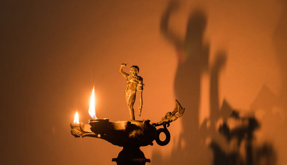 Öllampe mit mehreren Flammen und Figur.