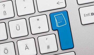 weiße Computertastatur mit blauer Entertaste, auf der ein Icon eines Dokuments abgebildet ist