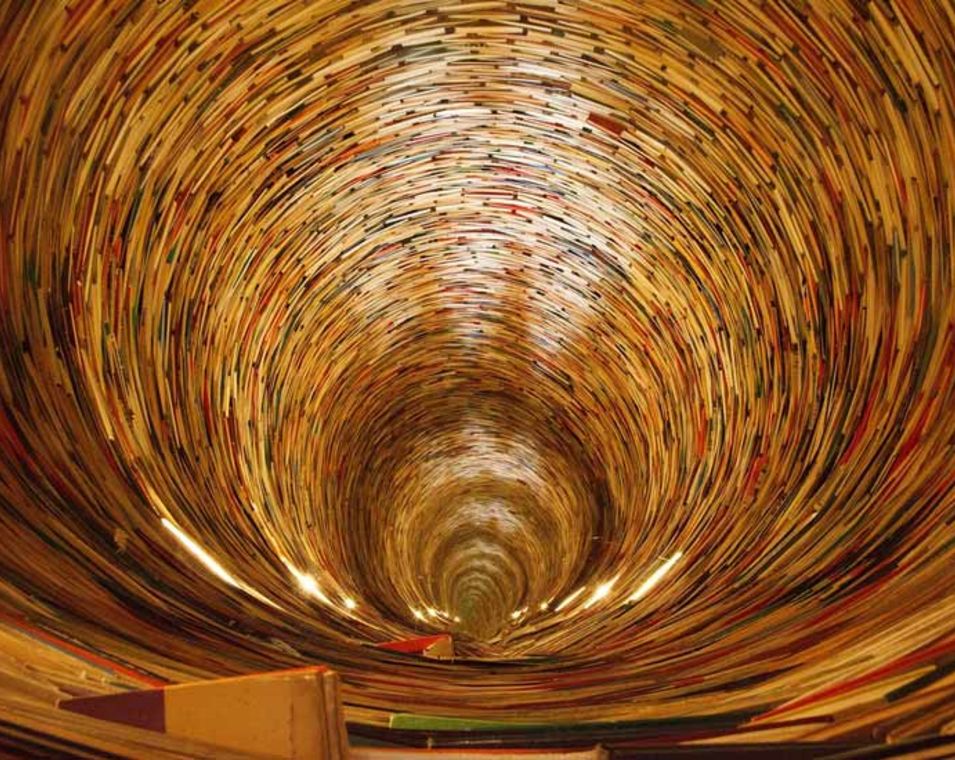 Bücher sind wie in einer Art Tunnel mit Saugwirkung angeordnet. 