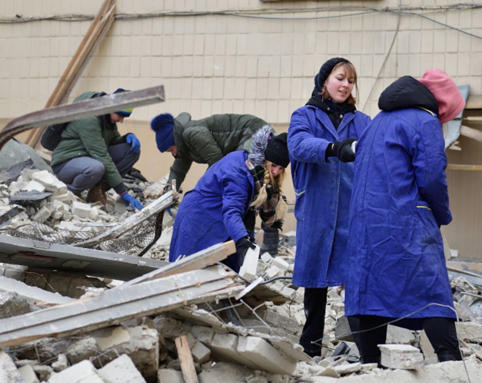 Studierende der Universität Charkiw beseitigen Trümmer nach einem Raketeneinschlag.