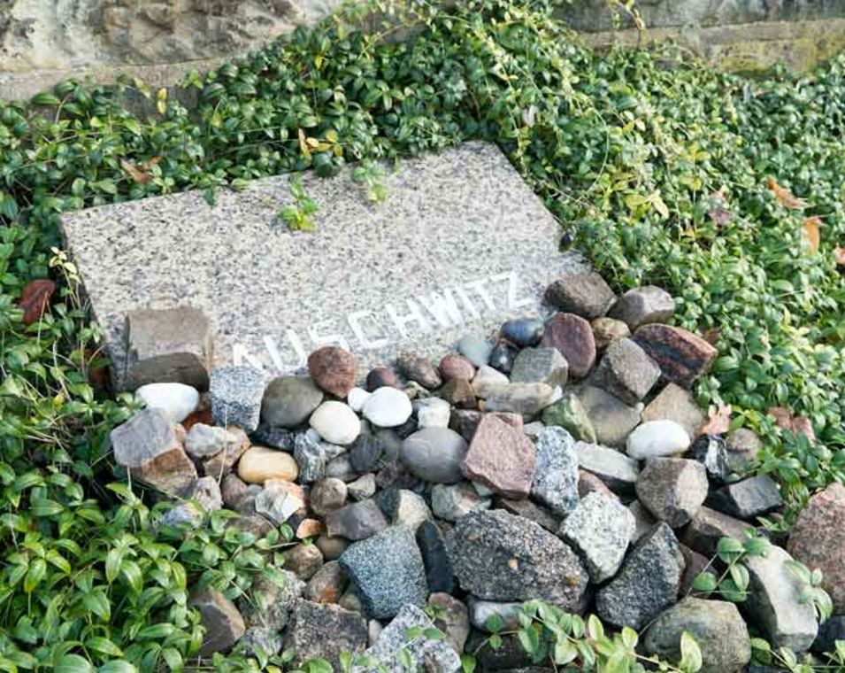 Steinplatte mit der Aufschrift Auschwitz zum Gedenken an den Holocaust auf dem Jüdischen Friedhof Berlin Weißensee