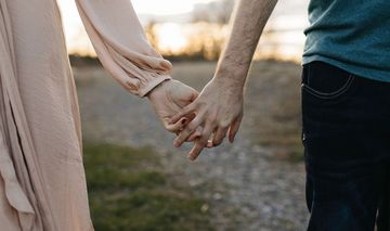 Frau und Mann halten sich an der Hand