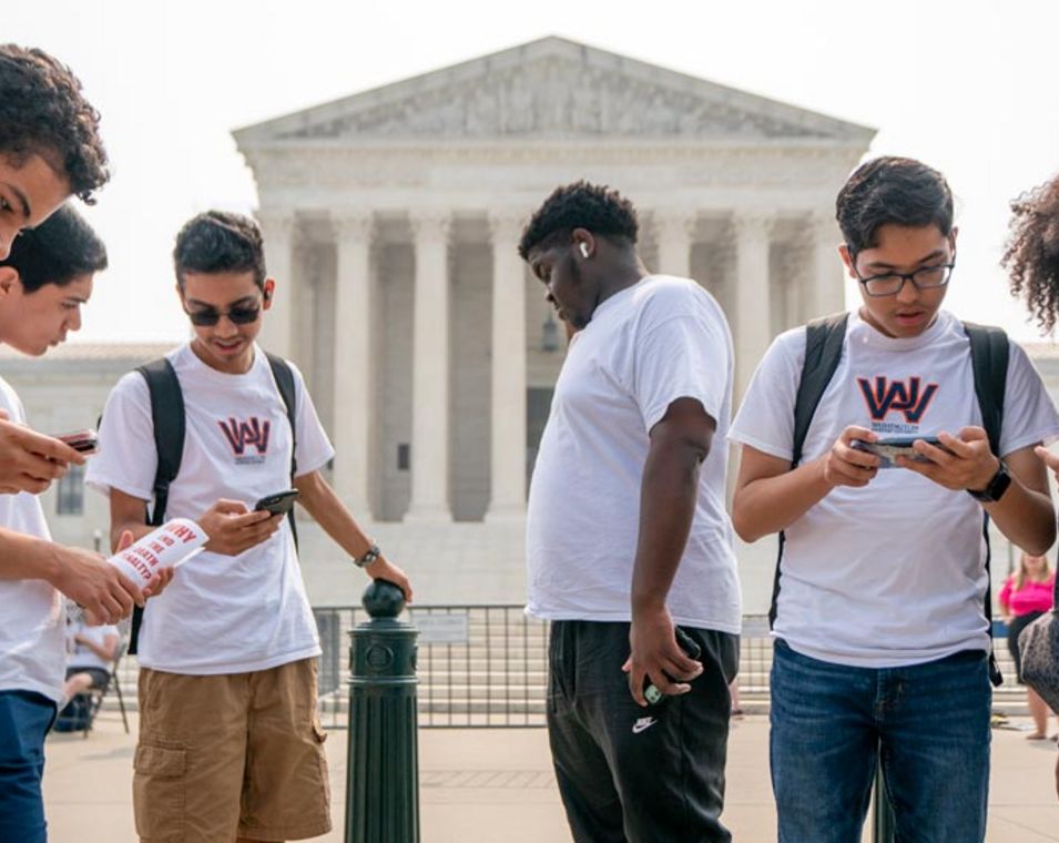 Studierende der Washington Adventist University stehen vor dem Supreme Court in Washington und lesen dessen Urteil zu "affirmative action" an US-Universitäten auf ihren Smartphones.