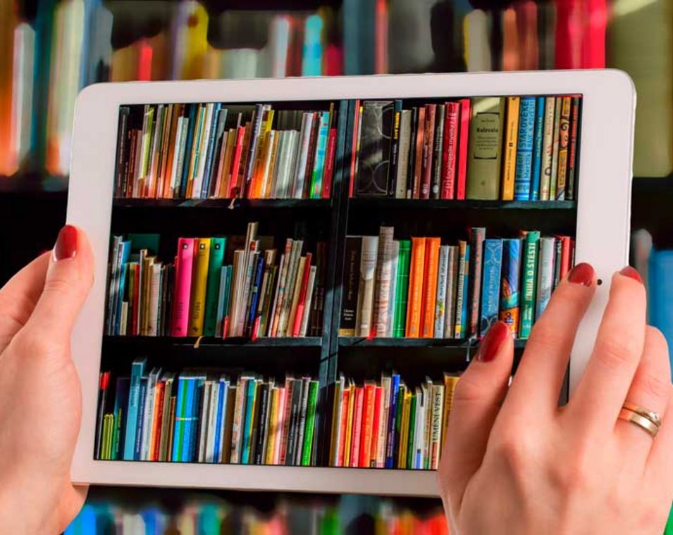 Eine Person blickt durch ein durchsichtiges Tablet auf ein Bücherregal
