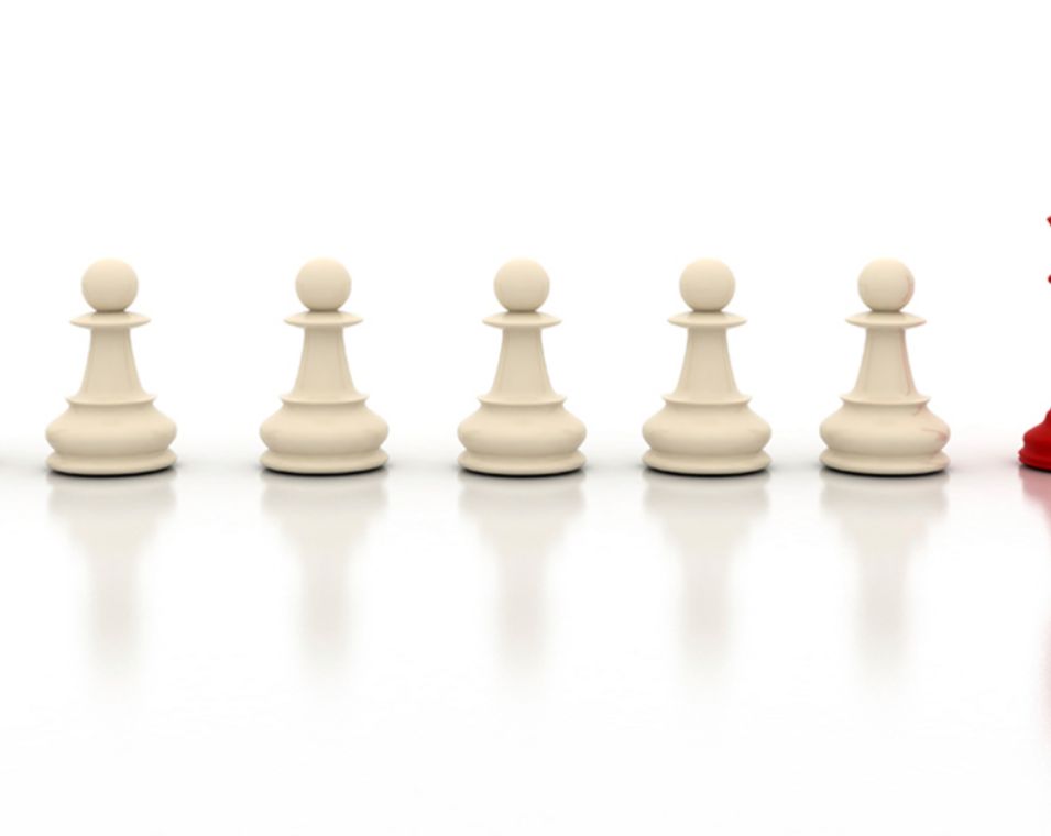 Schachfiguren stehen in einer Reihe: vier weiße Bauern und ein roter König.
