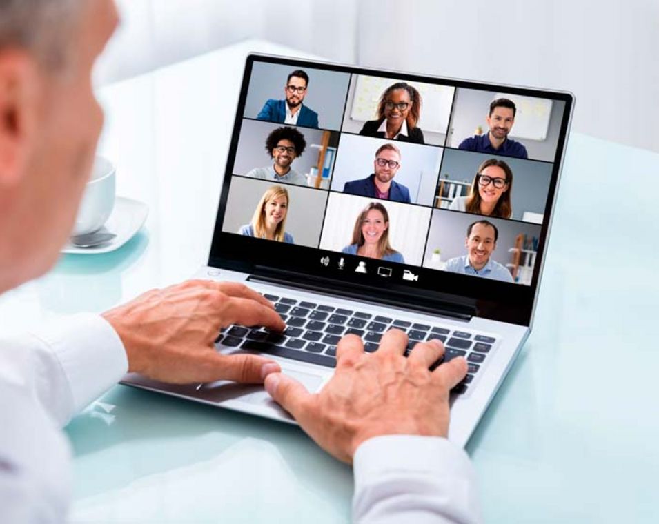 Mann nimmt per Laptop an einer Videokonferenz mit 9 Personen teil