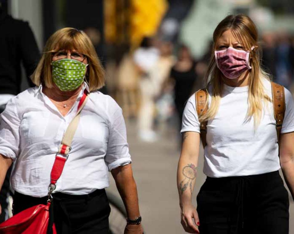 zwei Frauen mit selbstgenähten Munschutzmasken in einer Fußgängerzone