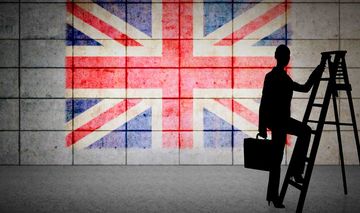 Eine Frau steigt mit Aktenkoffer auf eine Leiter. Im Hintergrund ist die britische Fahne auf eine Wand gemalt.