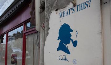 Plakat mit Kopf von Sherlock Holms vor Restaurant mit Schriftzug "What's this?"
