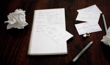 Schreibunterlagen auf einem Tisch mit handschriftlichen Notizen
