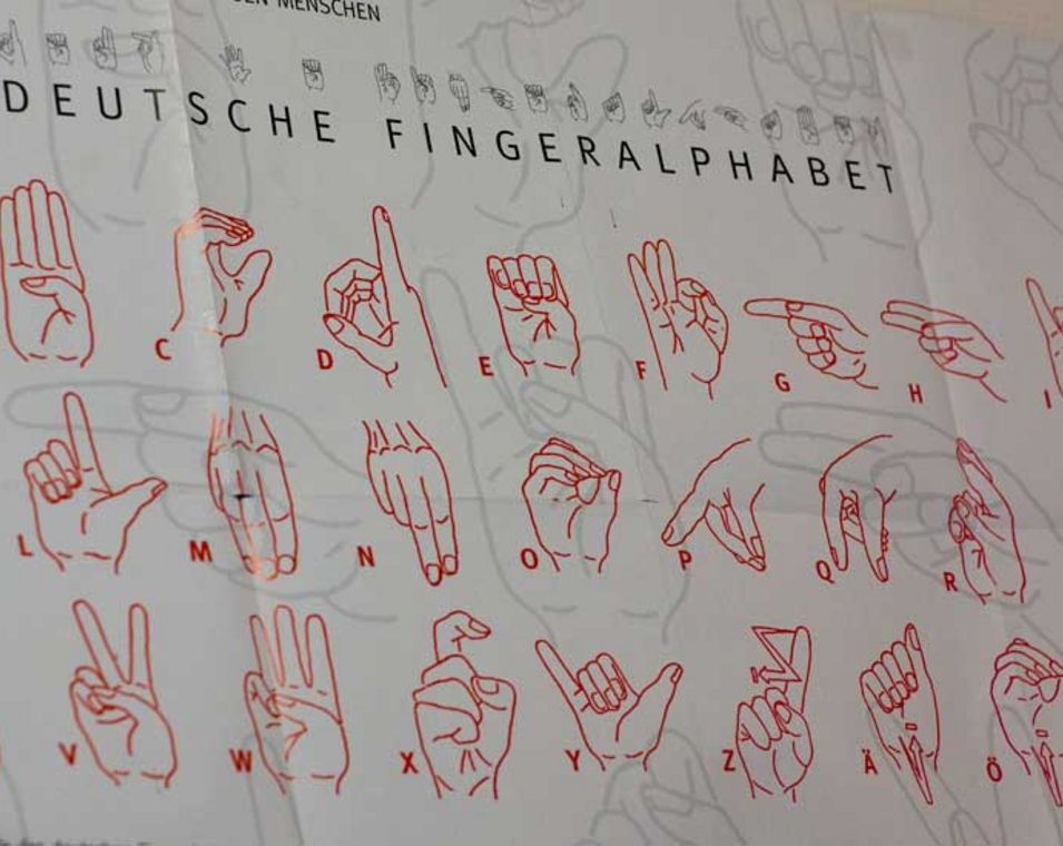 Ein Plakat mit dem Fingeralphabet der Deutschen Gebärdensprache.