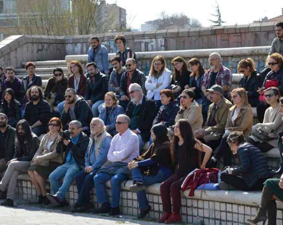 Eine türkische Wissenschaftler hält vor einer Gruppe von Menschen im Freien einen Vortrag 
