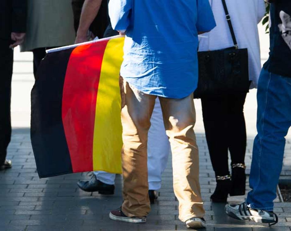 Ein Teilnehmer mit einer Deutschland-Flagge kommt zum Treffen der AfD-Gruppierung "Der Flügel".