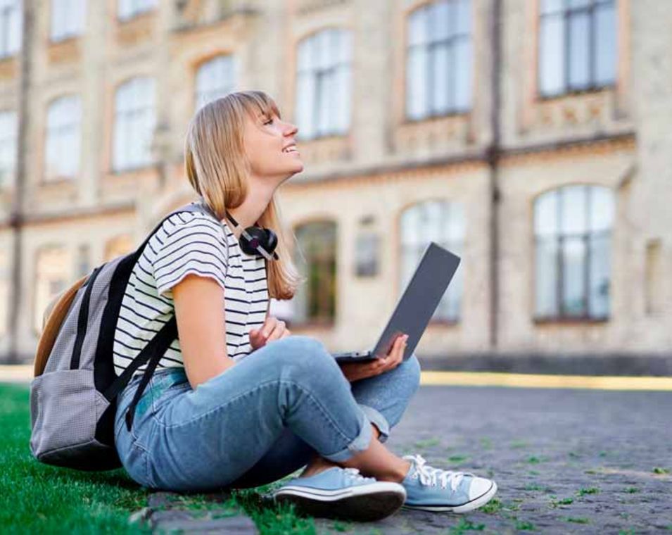 Studentin mit Laptop auf einem Universitätsgelände