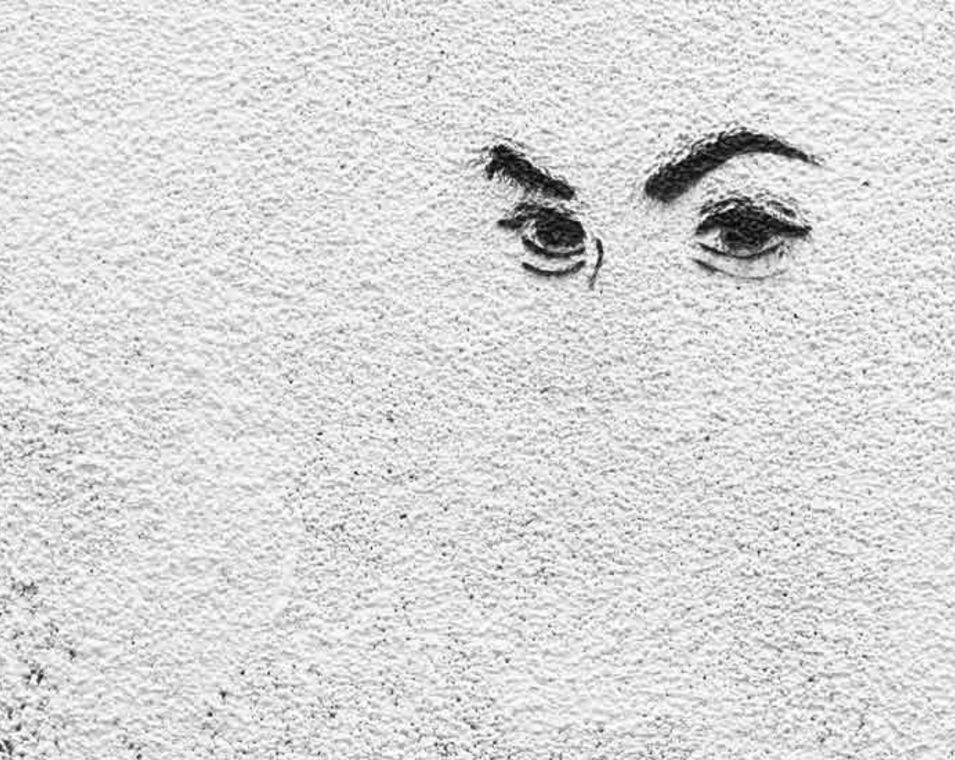 Ein Augenpaar gemalt auf eine weiße Mauer