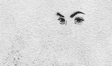 Ein Augenpaar gemalt auf eine weiße Mauer