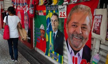 Eine Passantin geht an einem Straßenverkaufsstand in Rio de Janeiro vorbei, der Handtücher mit den Gesichtern der Präsidentschaftskandidaten der Republik Brasilien verkauft.