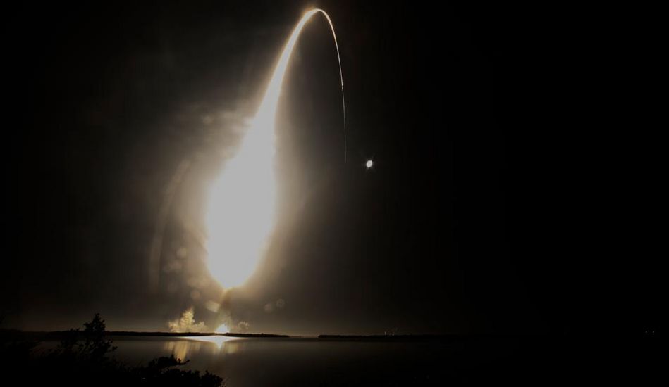 Nachtansicht des Raketenstarts mit hellem Schweif in Richtung Mond