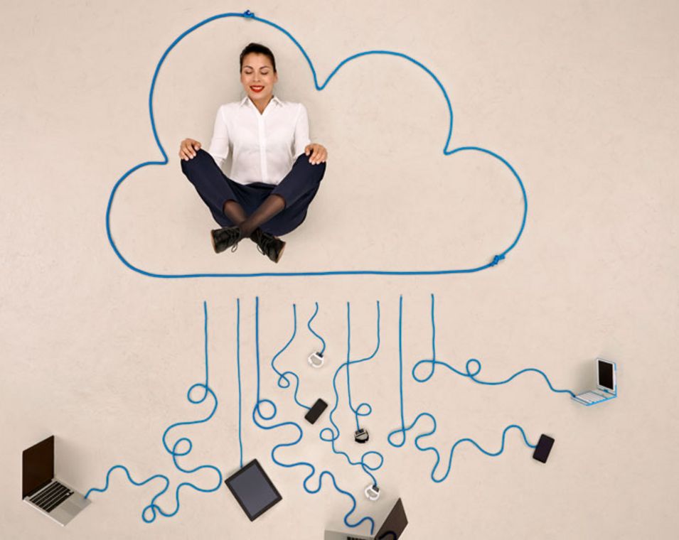 Symbolbild: Geschäftsfrau meditiert in einer Wolke, die mit verschiedenen mobilen Geräten verbunden ist