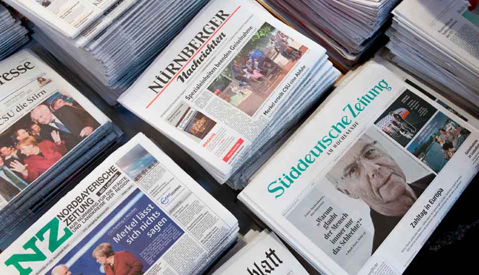 Das Bild zeigt eine Auslage mit vielen verschiedenen Zeitungen