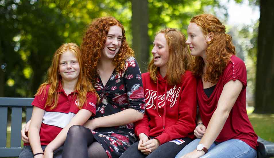 Das Foto zeigt eine Mutter mit drei Töchtern, die alle rote Haare haben.