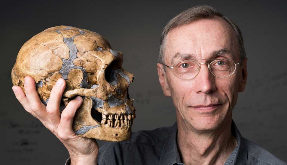 Das Foto zeigt den Körberpreisträger Svante Pääbo mit dem Schädel eines Neandertalers.