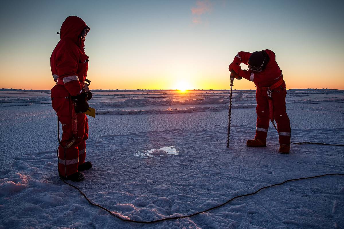 Forscher bohren Loch in Eisschicht