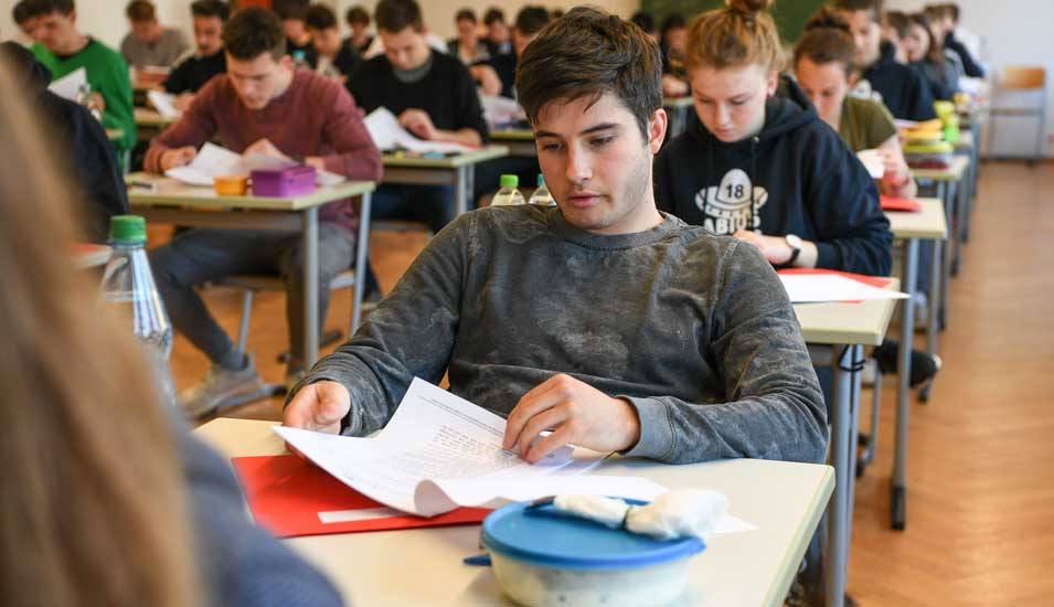 Das Foto zeigt einen Schüler an einem Tisch während der Abiturprüfung.