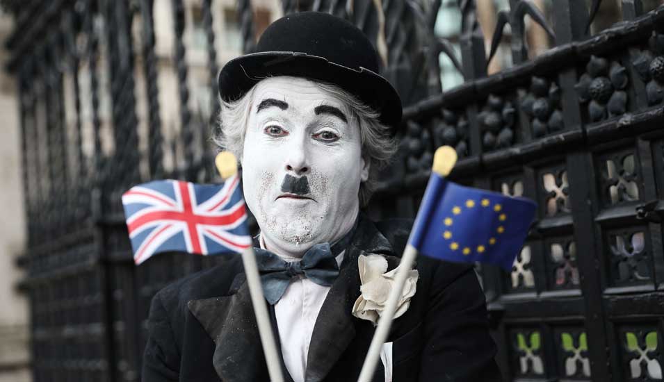 Als Charlie Chaplin verkleideter Pantomime-Künstler mit britischer und europäischer Mini-Fahne