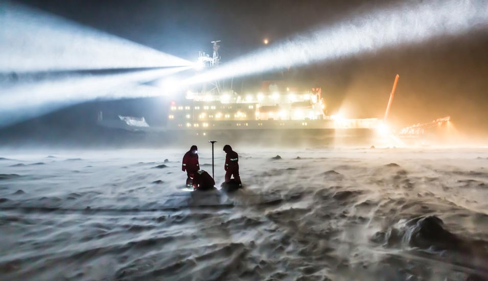 Forscher vor dem Forschungsschiff "Polarstern"