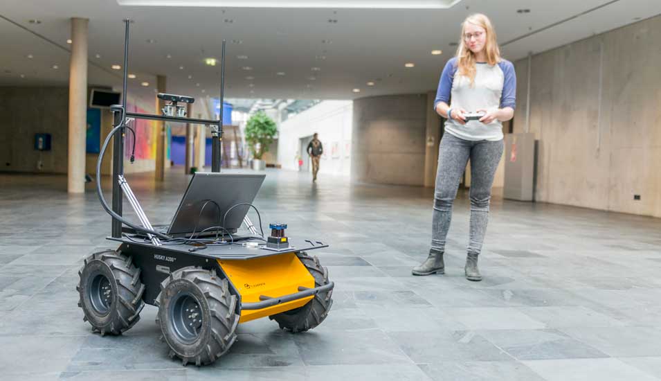 Studentin steuert ein Roboter-Auto