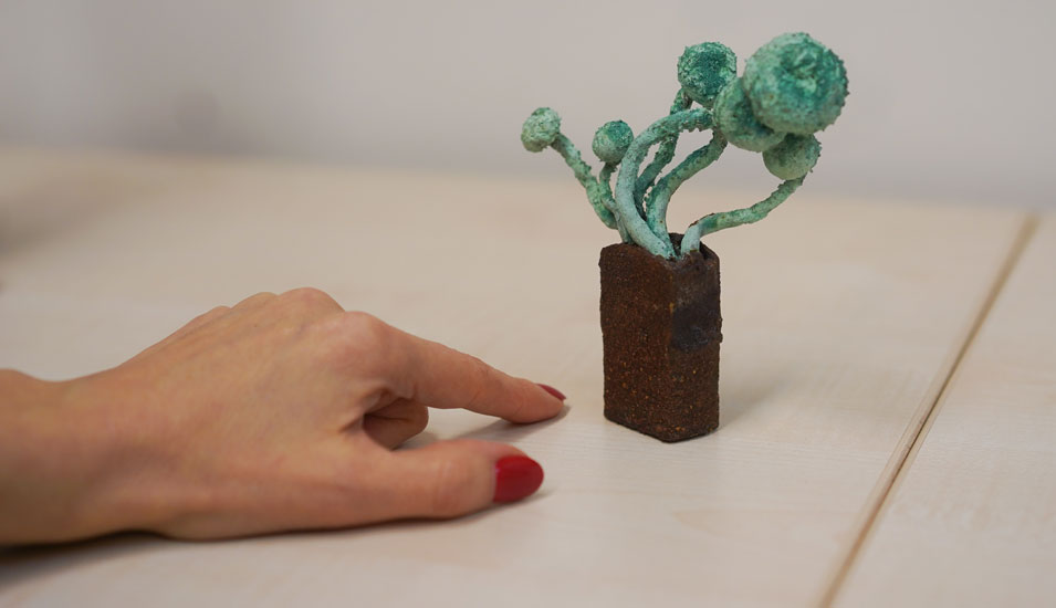 Das Foto zeigt eine Hand und eine Skulptur, die aus einem Hallimasch-Pilz besteht.
