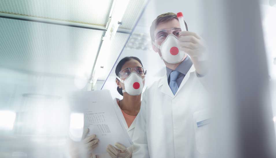 Forscherin und Forscher in einem Labor mit Mundschutz