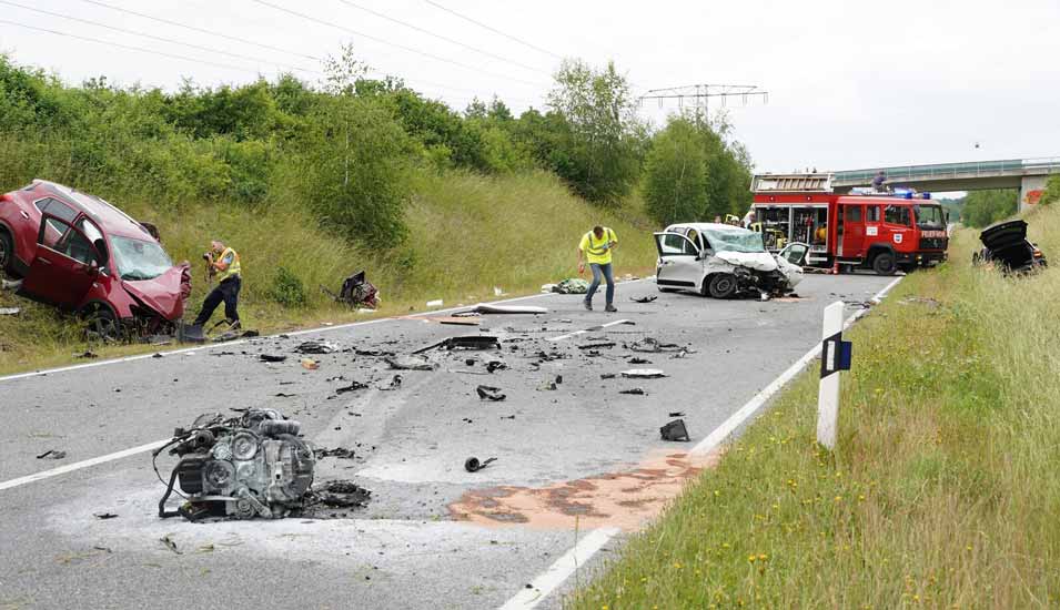 Zwei Männer sichern nach einem schweren Zusammenstoß von drei Fahrzeugen Spuren auf der Staatsstraße 94 in Sachsen.