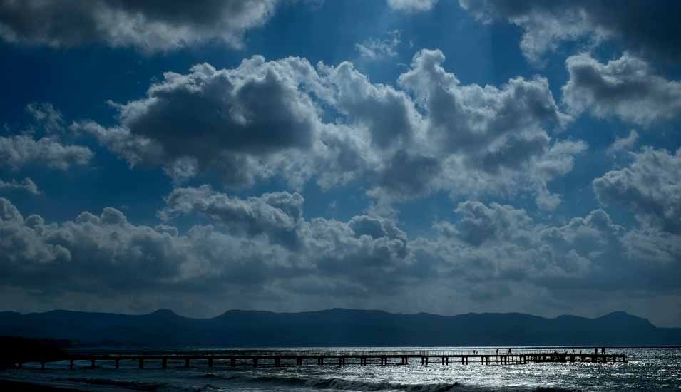 Steg am Strand auf Zypern vor einem stürmischen Meer und wolkigen Himmel