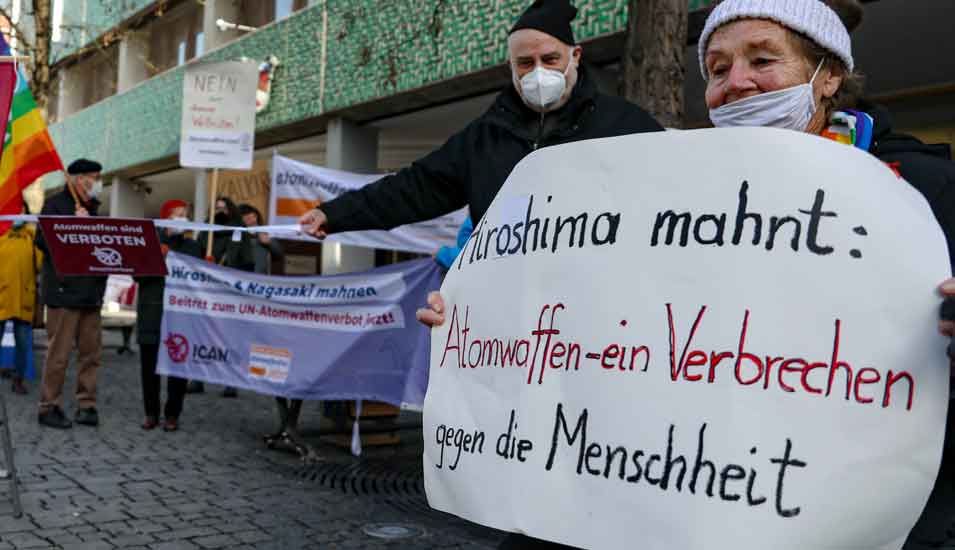 Proteste gegen Atomwaffen von Februar 2021: Eine Frau trägt ein Plakat mit der Aufschrift "Hieroshima mahnt: Atomwaffen - ein Verbrechen gegen die Menschheit".