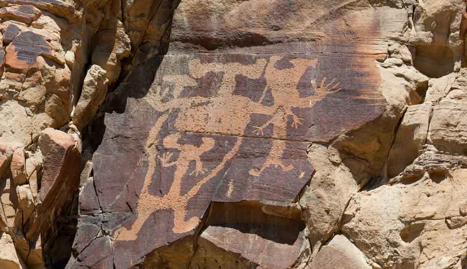 Darstellung eines großen, menschenähnlichen Wesens (Anthropomorph) in einem Sandsteinfelsen in der Legend Rock State Petroglyph Site in Wyoming, USA.